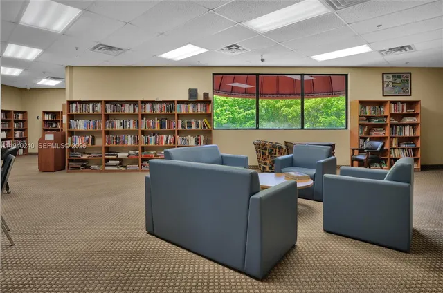 a living room with furniture a window and bookshelf