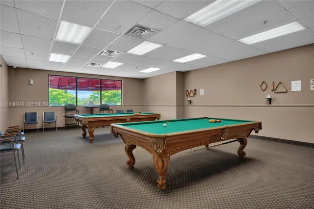 a room with pool table and windows