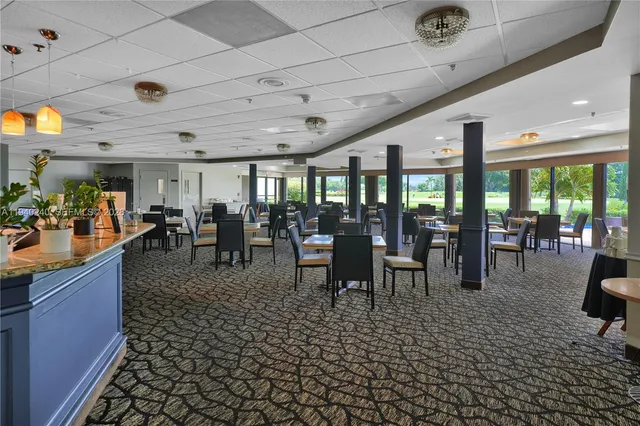 a view of a dining hall with lots of furniture and large windows