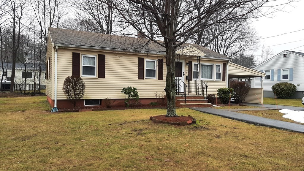 a view of a yard in front of a house with a patio