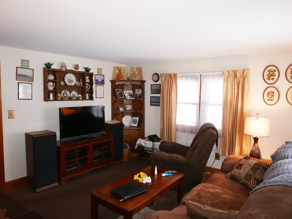 19 Glenmere Street Lowell, MA 01852 - Photo 8 of 12 a living room with furniture a window and a flat screen tv