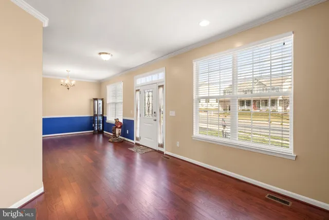 a large kitchen with stainless steel appliances granite countertop a stove a sink dishwasher a refrigerator and a dining table with wooden floor