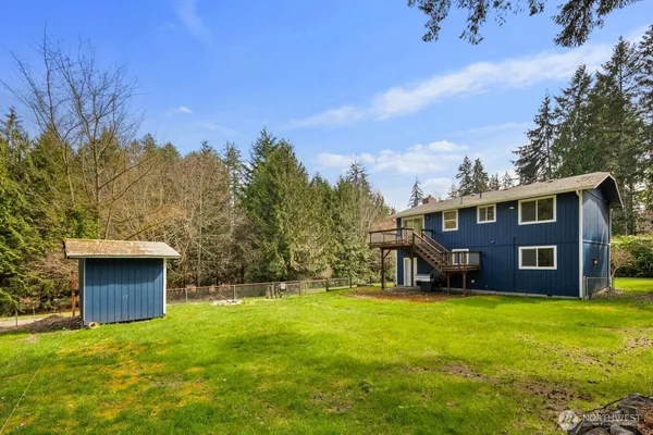 a view of a house with a big yard and large trees