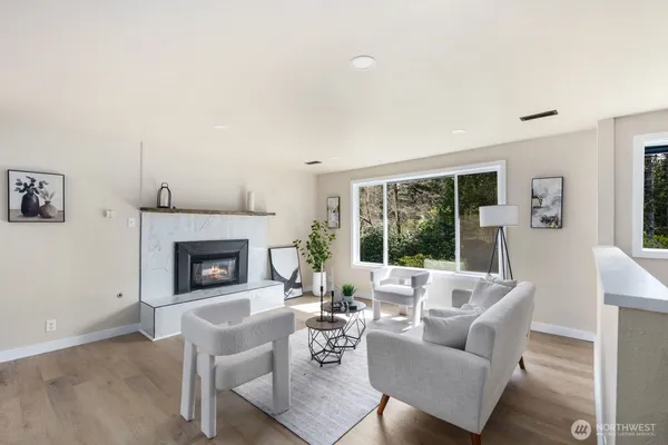 a living room with furniture potted plant a fireplace and a window