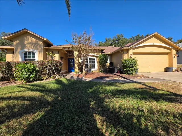 a front view of a house with yard and green space
