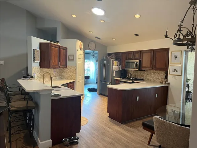 a kitchen with kitchen island stainless steel appliances a sink stove and refrigerator