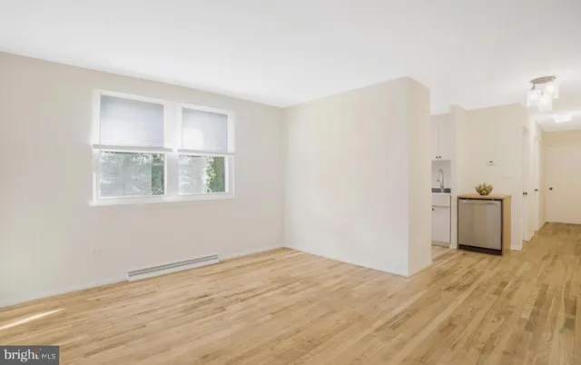 a view of a room with wooden floor and a window