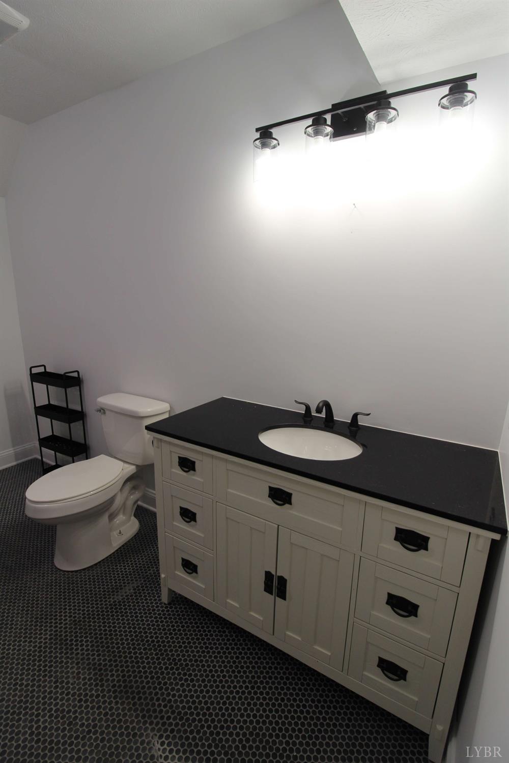 2899 Thomas Jefferson Road Forest, VA 24551 - Photo 15 of 22 a bathroom with a granite countertop sink a toilet and a mirror