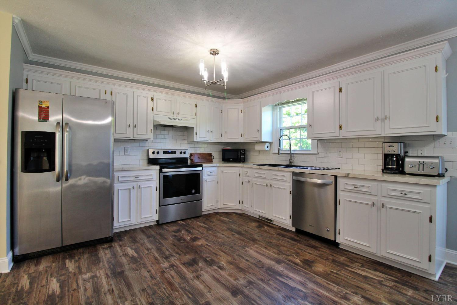 2899 Thomas Jefferson Road Forest, VA 24551 - Photo 4 of 22 a kitchen with cabinets wooden floor and stainless steel appliances
