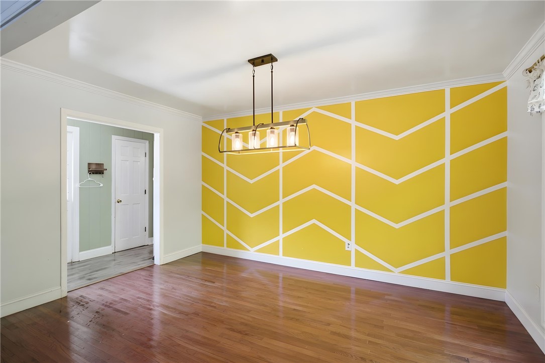 311 Cumberland Way Anderson, SC 29621 - Photo 6 of 44 Hardwood floors and a distinctive geometric accent wall define this versatile space.