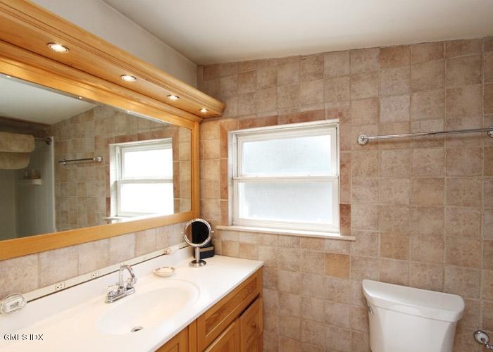 446 Valley Road Cos Cob, CT 06807 - Photo 7 of 9 a bathroom with a sink a toilet a mirror and a window