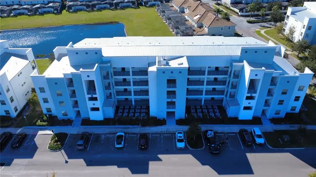 a room with stainless steel appliances kitchen island granite countertop a sink a stove and a refrigerator with wooden floor