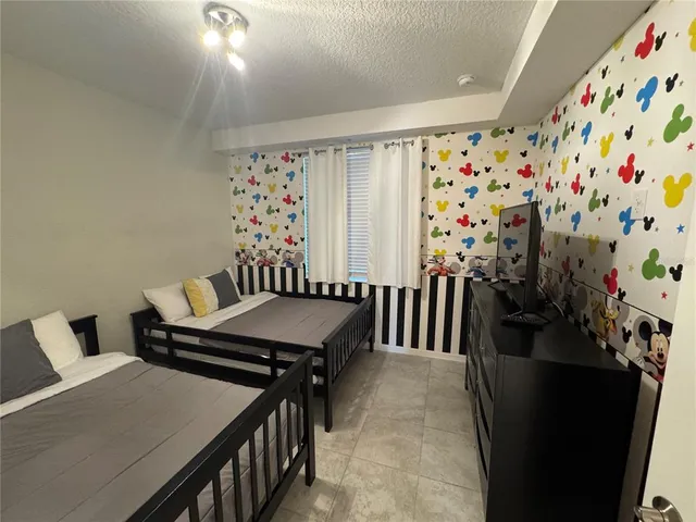 a bedroom with two beds and a chandelier