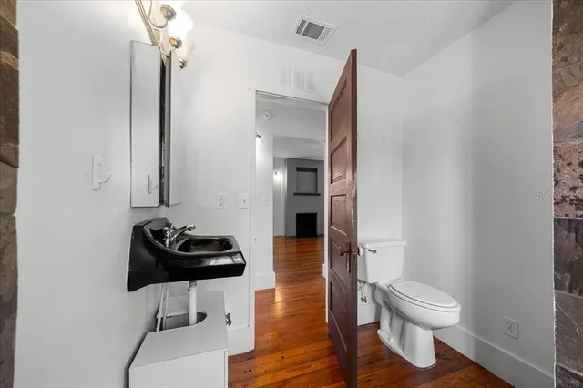 a bathroom with a toilet a sink and mirror