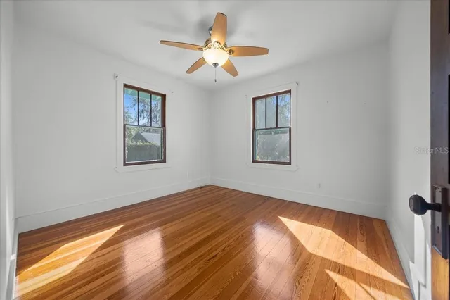 a view of empty room with wooden floor