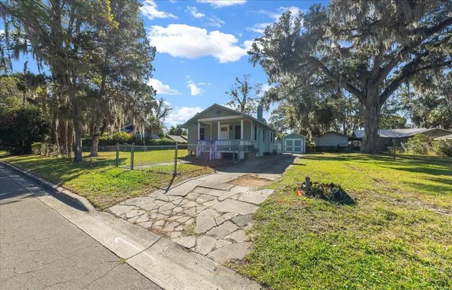 a view of swimming pool with deck and large trees