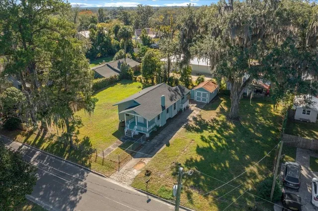 aerial view of a house with swimming pool and large trees