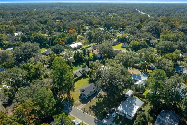 an aerial view of residential house with outdoor space and trees all around