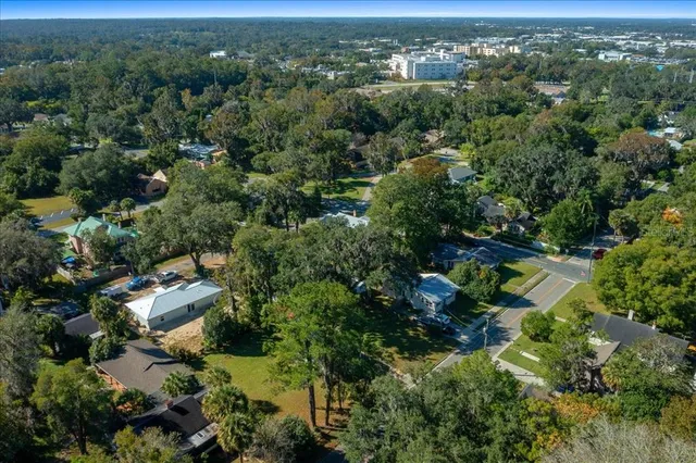 an aerial view of residential houses with outdoor space and trees