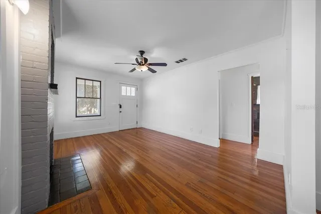a view of empty room with wooden floor