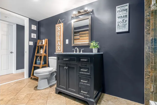 a bathroom with a toilet a sink and a mirror