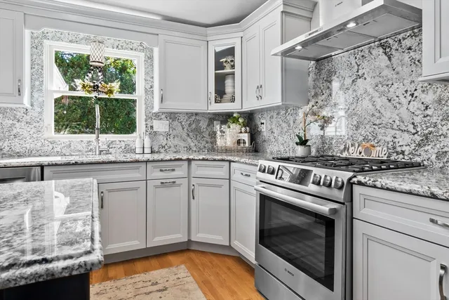 a kitchen with stainless steel appliances granite countertop a stove a sink and a microwave
