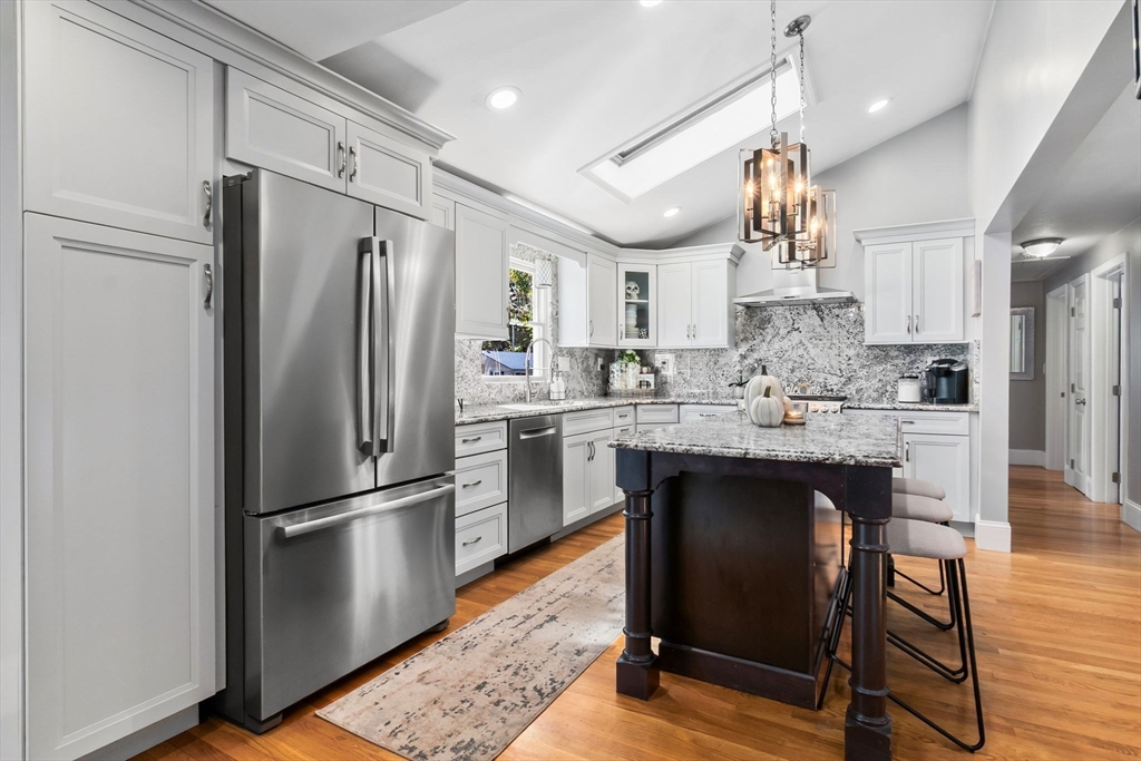 6 Susan Drive Saugus, MA 01906 - Photo 5 of 34 a kitchen with stainless steel appliances a refrigerator a sink dishwasher a stove and white cabinets with wooden floor