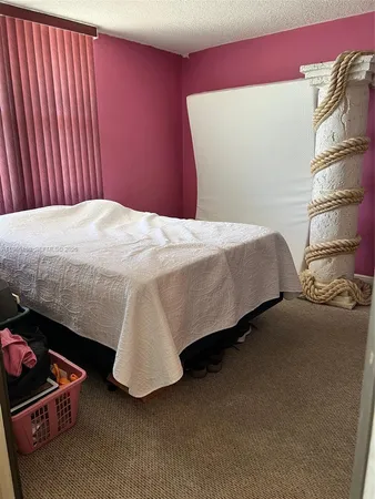 a bed sitting in a bedroom next to a window