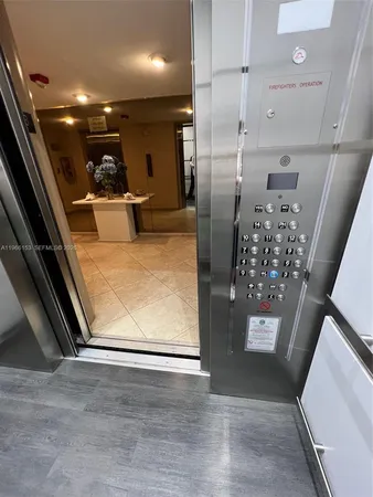 a view of a refrigerator in kitchen and an empty room