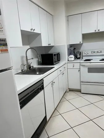 a kitchen with granite countertop white cabinets and white appliances