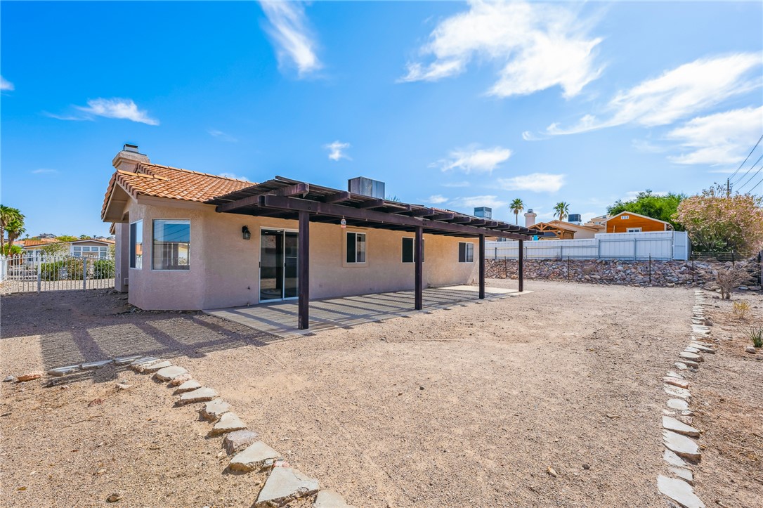 2524 South Ridge Avenue Bullhead City, AZ 86429 - Photo 51 of 64 Back of house with a chimney, stucco siding, a patio, a pergola, and a tile roof