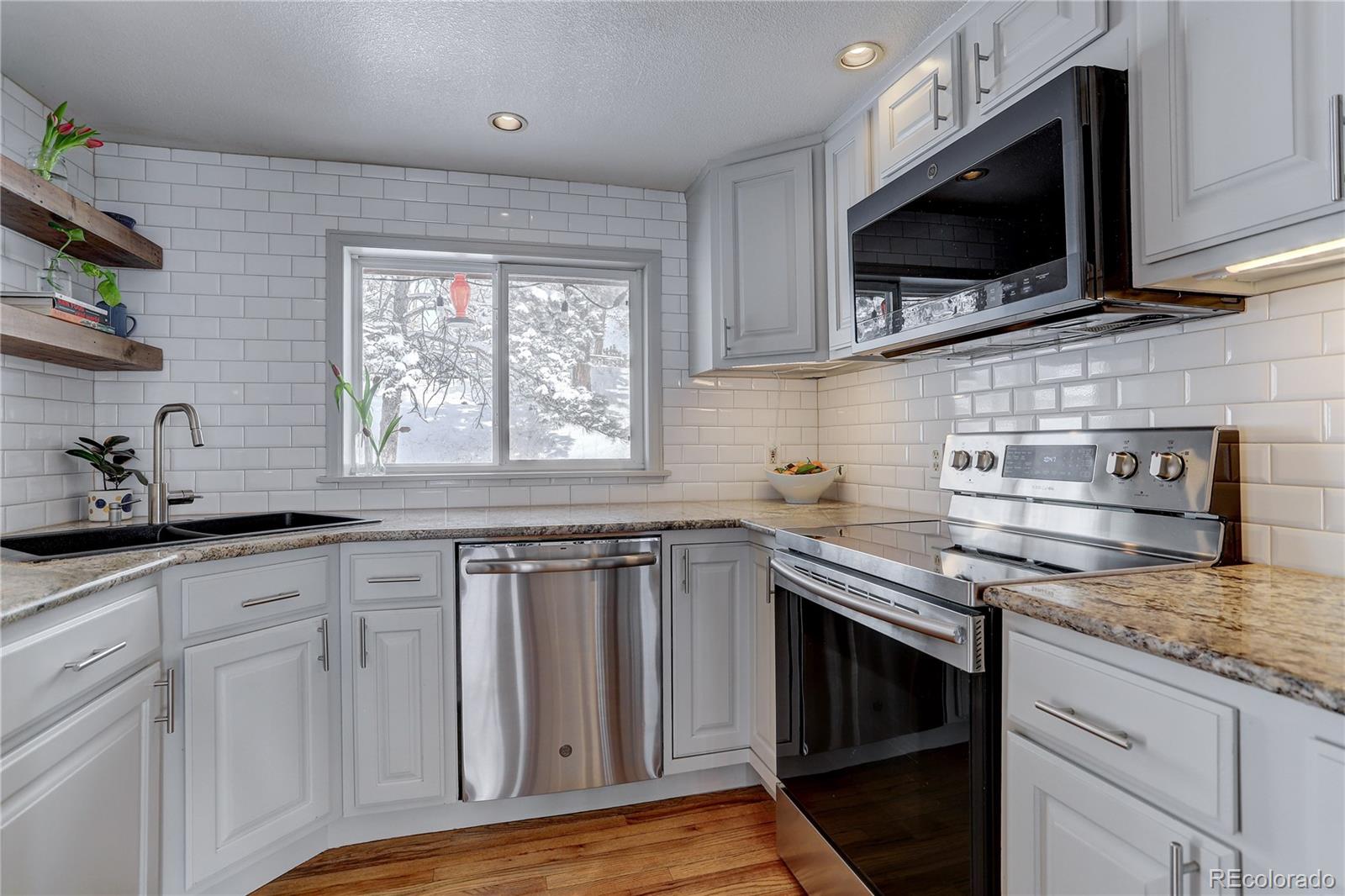 1094 Colorow Road Golden, CO 80401 - Photo 19 of 40 a kitchen with stainless steel appliances granite countertop a stove a sink and a microwave