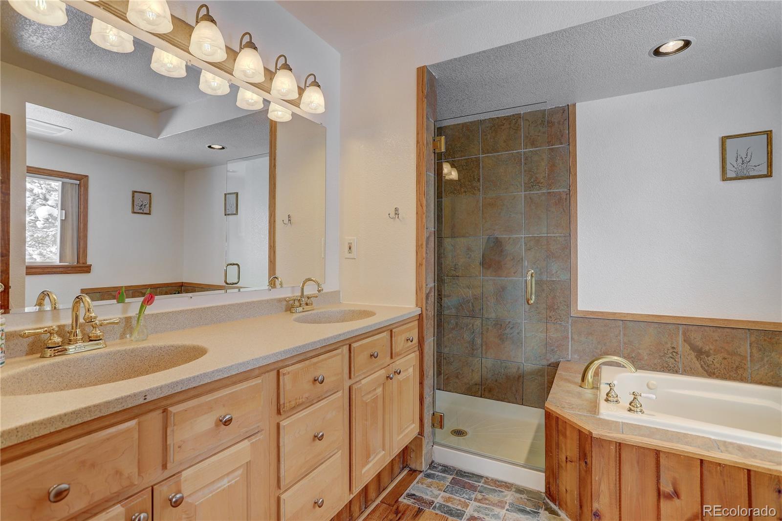 1094 Colorow Road Golden, CO 80401 - Photo 24 of 40 a bathroom with a tub a sink and mirror