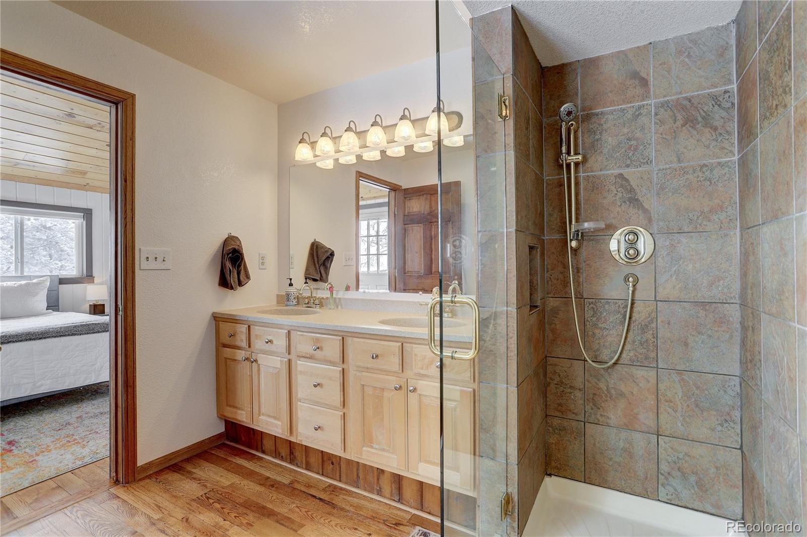 1094 Colorow Road Golden, CO 80401 - Photo 25 of 40 a spacious bathroom with a shower sink and mirror