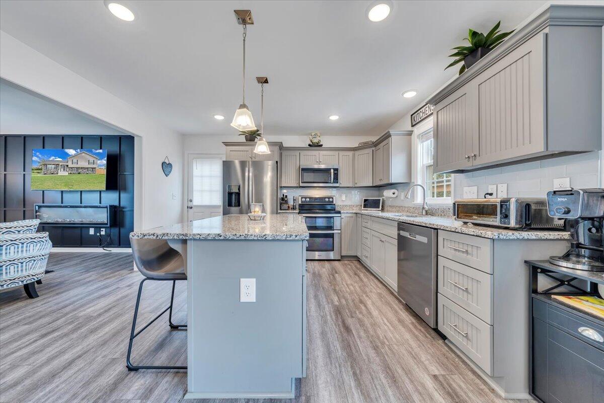 4018 Hazelridge Road Northwest Roanoke, VA 24012 - Photo 8 of 59 a kitchen with stainless steel appliances granite countertop a refrigerator a stove a sink dishwasher and a dining table with wooden floor