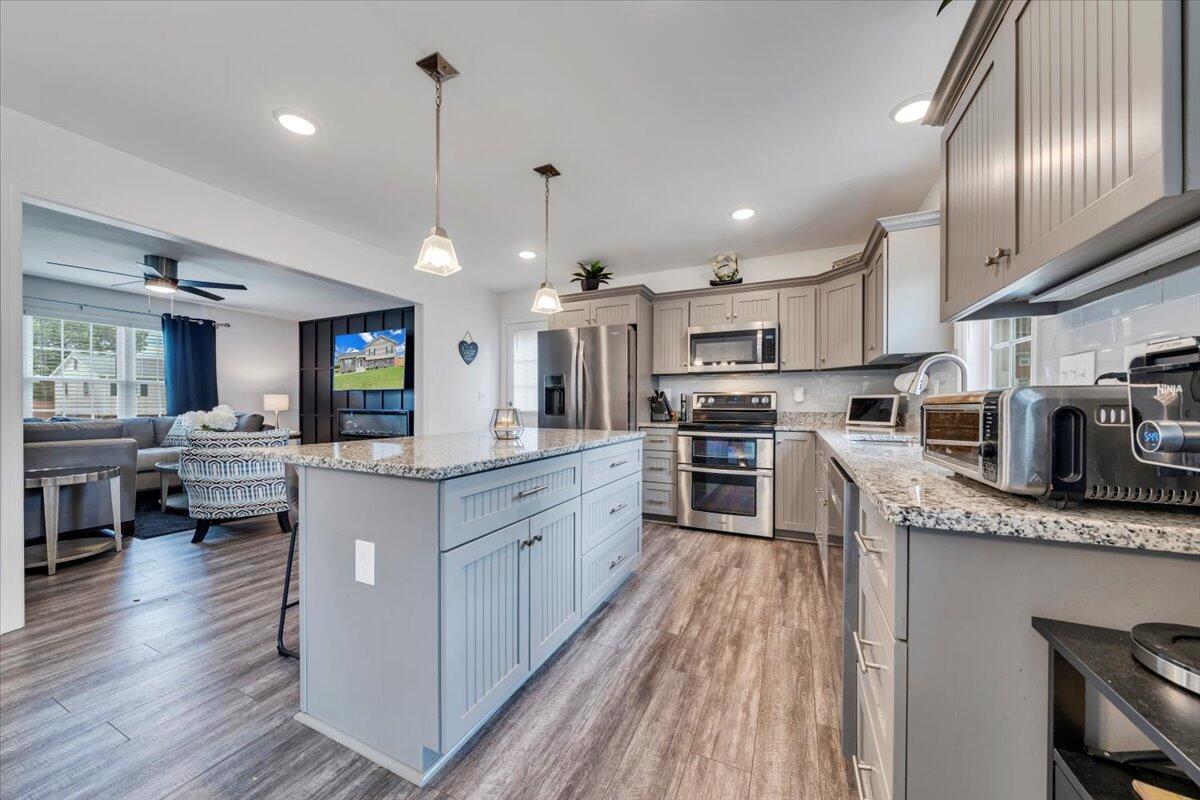 4018 Hazelridge Road Northwest Roanoke, VA 24012 - Photo 9 of 59 a kitchen with stainless steel appliances kitchen island granite countertop a stove top oven a sink dishwasher a dining table and chairs with wooden floor