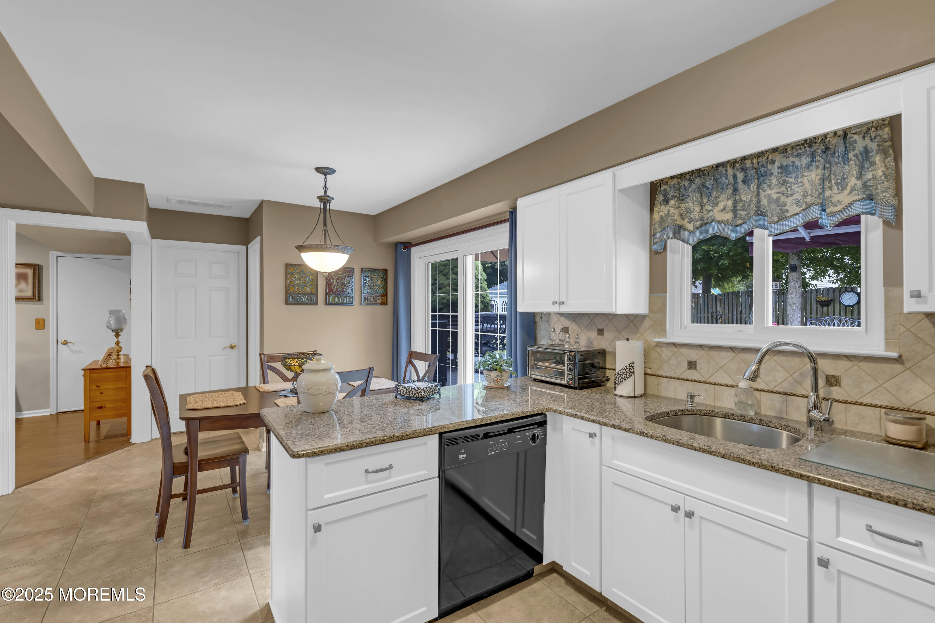 32 Kiwi Loop Howell, NJ 07731 - Photo 12 of 42 a kitchen with granite countertop a sink and white cabinets with wooden floor