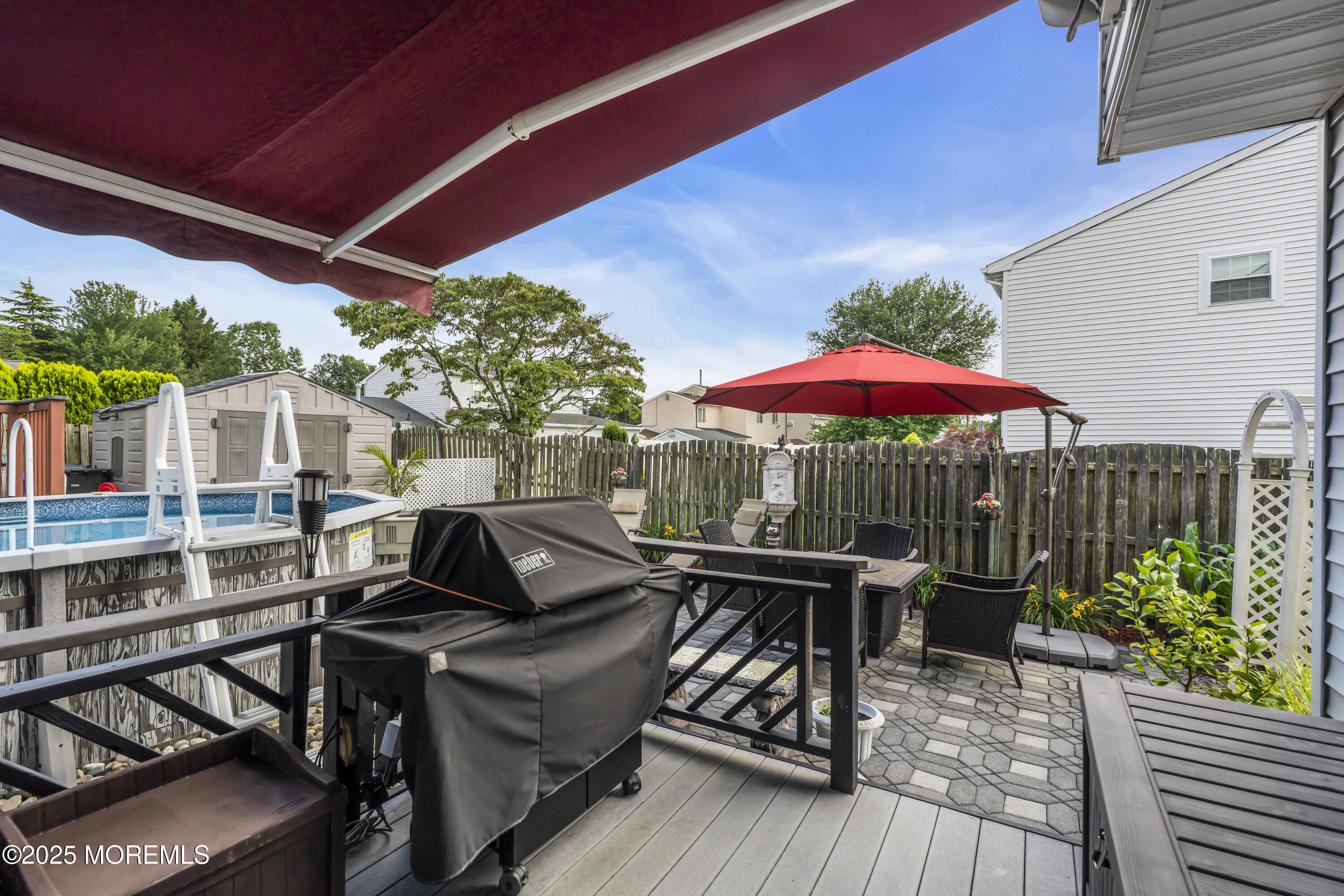 32 Kiwi Loop Howell, NJ 07731 - Photo 35 of 42 a view of a patio with a dining table and chairs under an umbrella