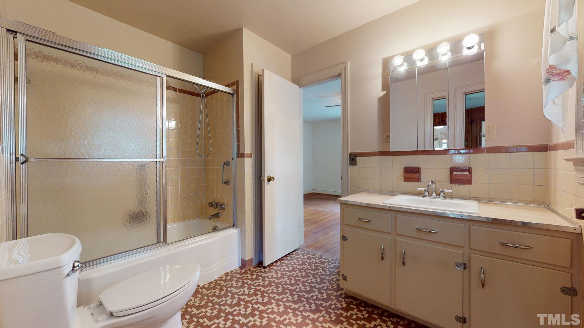 261 Badger Circle Roxboro, NC 27573 - Photo 16 of 30 a bathroom with a double vanity sink toilet mirror and shower