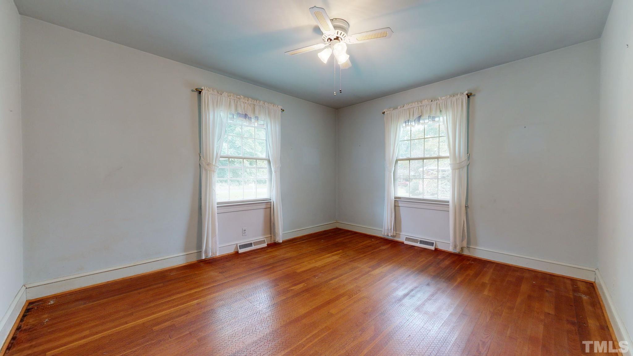 261 Badger Circle Roxboro, NC 27573 - Photo 17 of 30 a view of empty room with wooden floor and fan