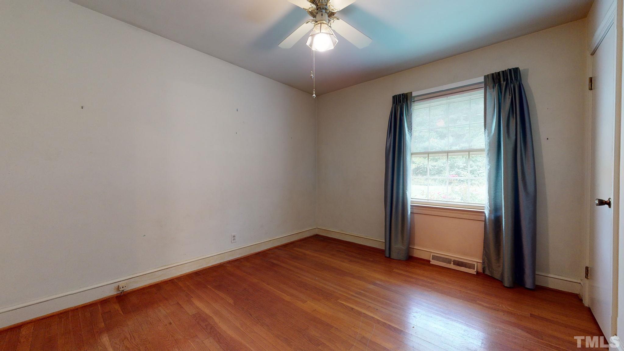 261 Badger Circle Roxboro, NC 27573 - Photo 18 of 30 an empty room with wooden floor chandelier and windows