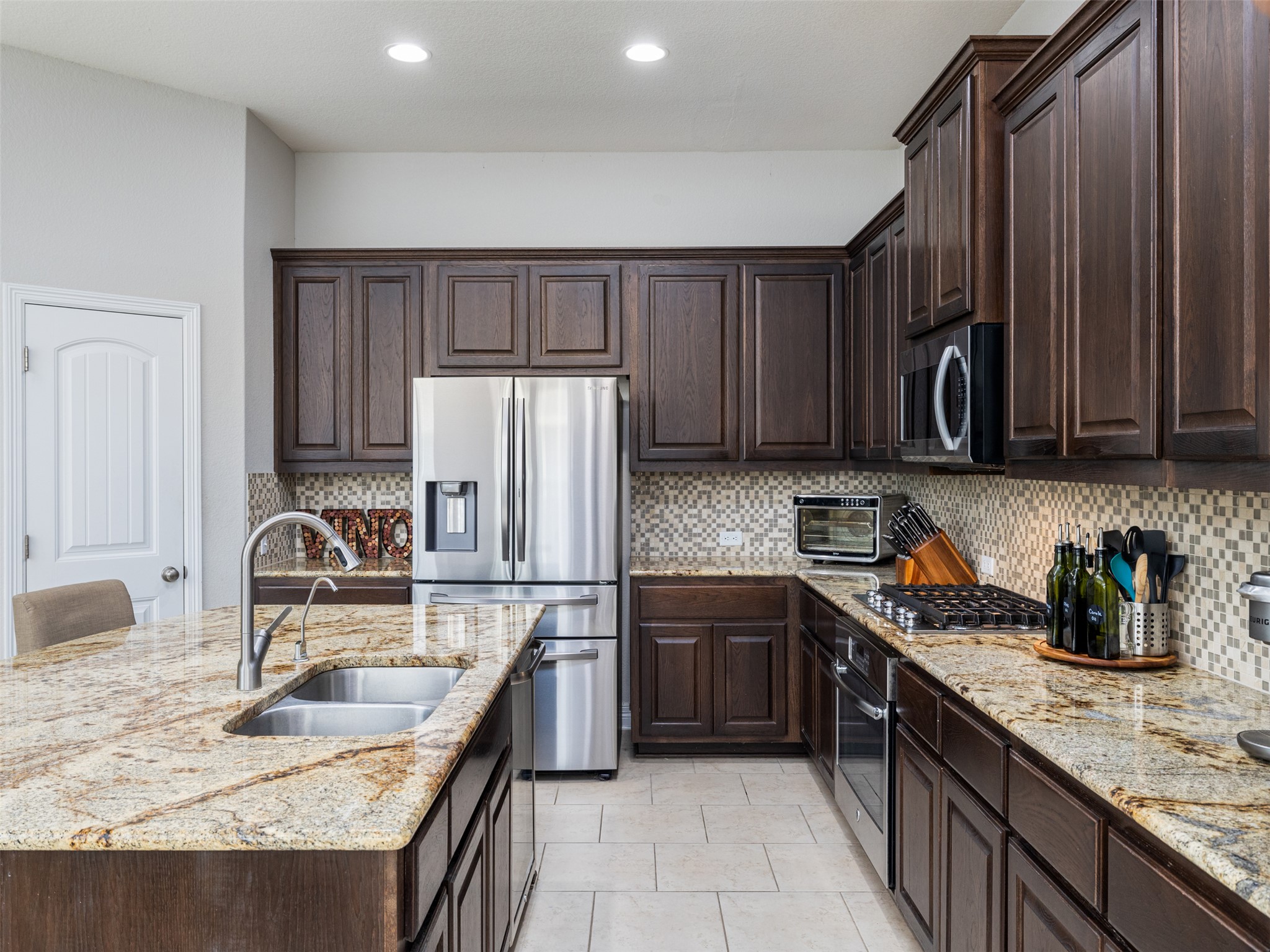 717 Blue Agave Lane Georgetown, TX 78626 - Photo 10 of 28 a kitchen with granite countertop a sink a stove and refrigerator