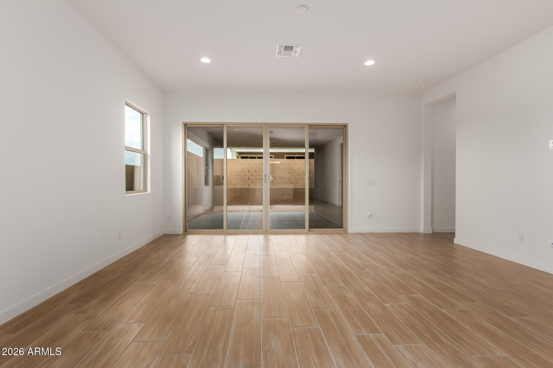 15890 West Miami Street Goodyear, AZ 85338 - Photo 7 of 51 an empty room with wooden floor and windows