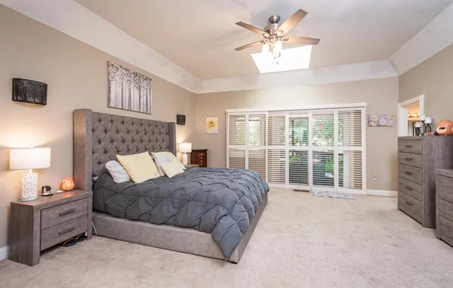 a spacious bedroom with a bed and a chandelier