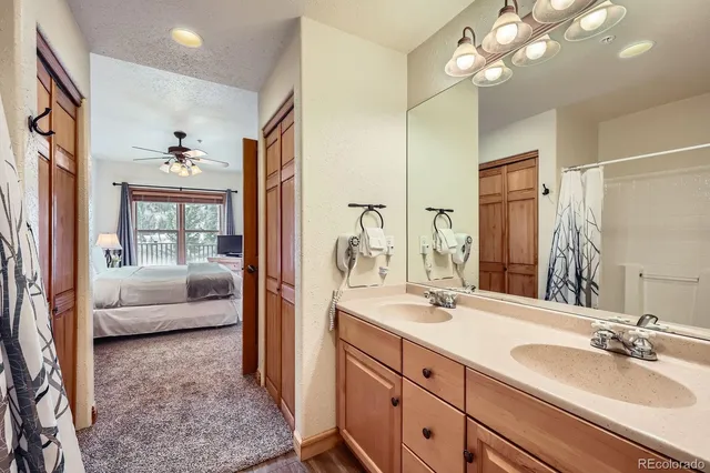 a en suite bathroom with a granite countertop sink a large mirror and shower