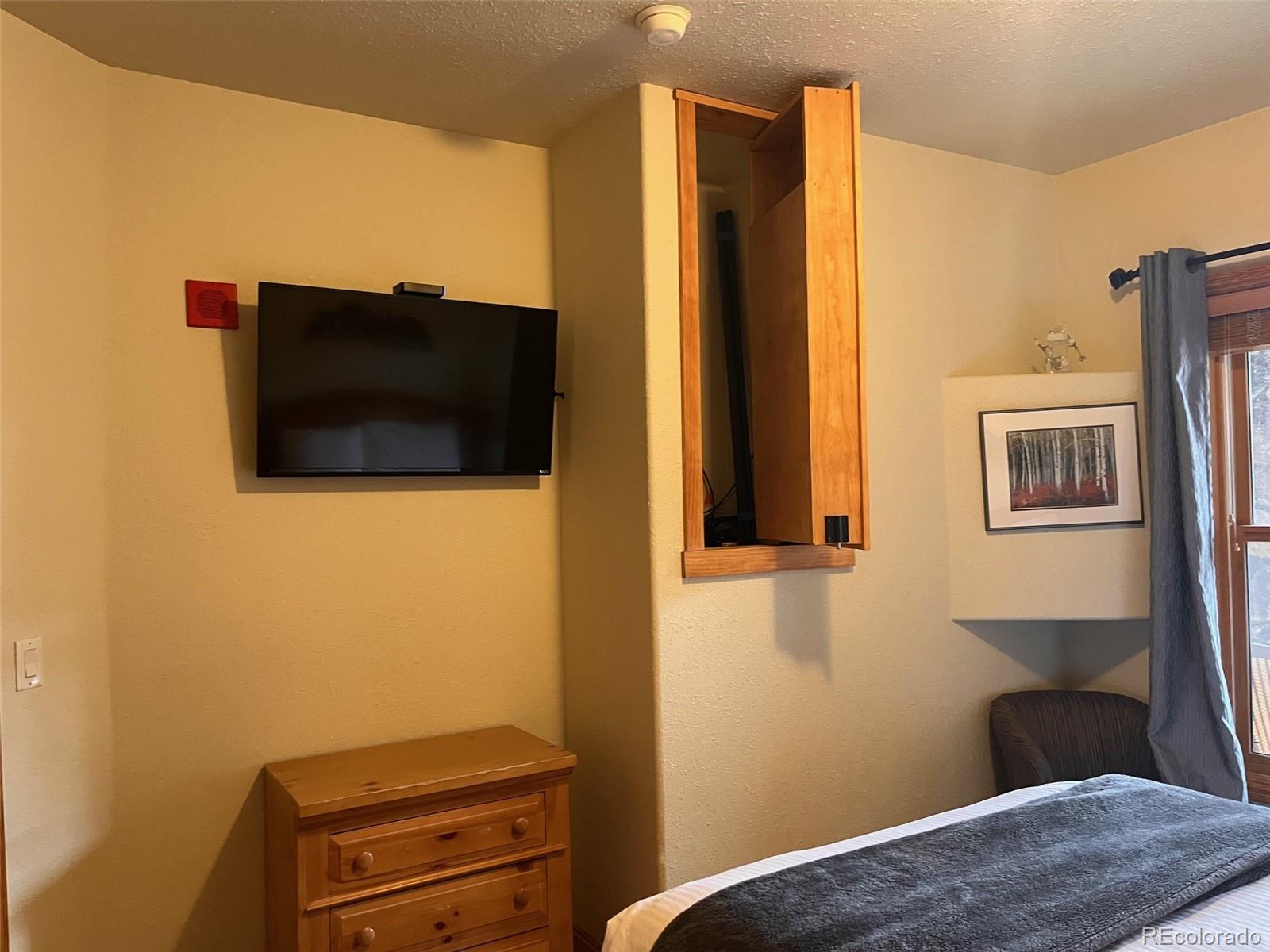 22714 Highway 6, Unit 5945 Keystone, CO 80435 - Photo 33 of 37 a bedroom with a bed and a flat screen tv