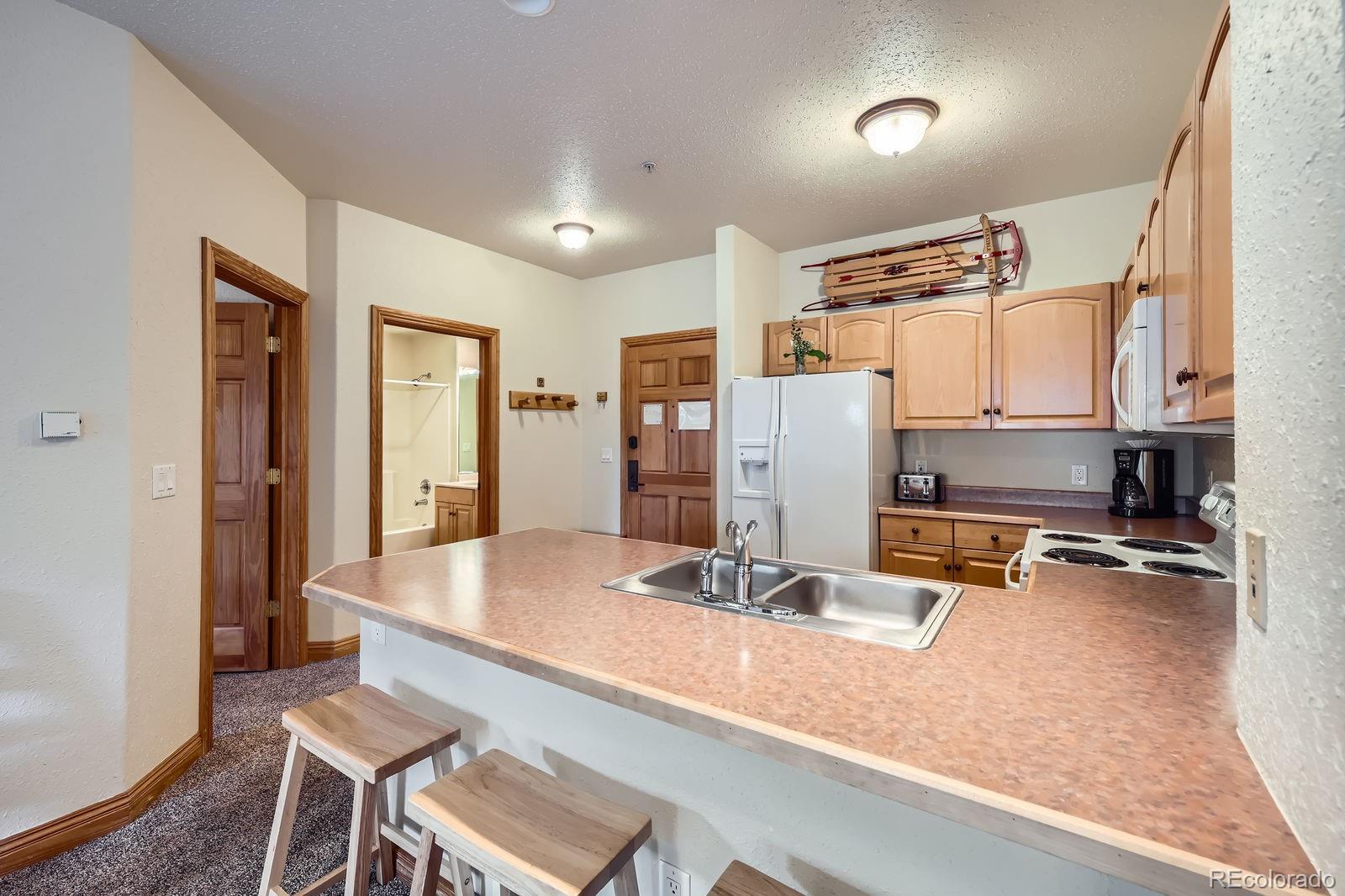 22714 Highway 6, Unit 5945 Keystone, CO 80435 - Photo 8 of 37 a dining hall with stainless steel appliances granite countertop a sink refrigerator and cabinets