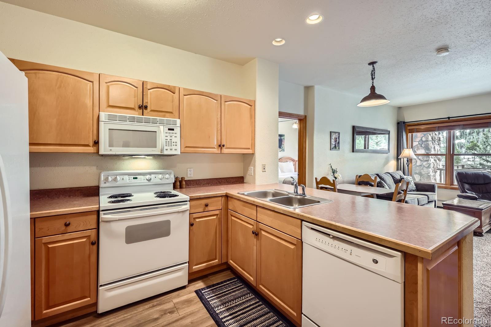22714 Highway 6, Unit 5945 Keystone, CO 80435 - Photo 9 of 37 a kitchen with stainless steel appliances granite countertop a sink stove and cabinets