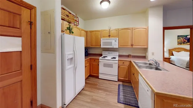 a kitchen with white cabinets and white appliances