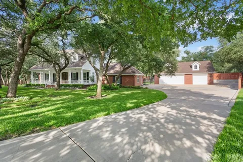 a front view of a house with a yard and trees